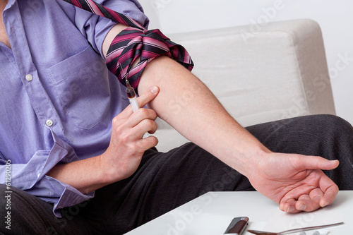 Addict preparing arm for injection