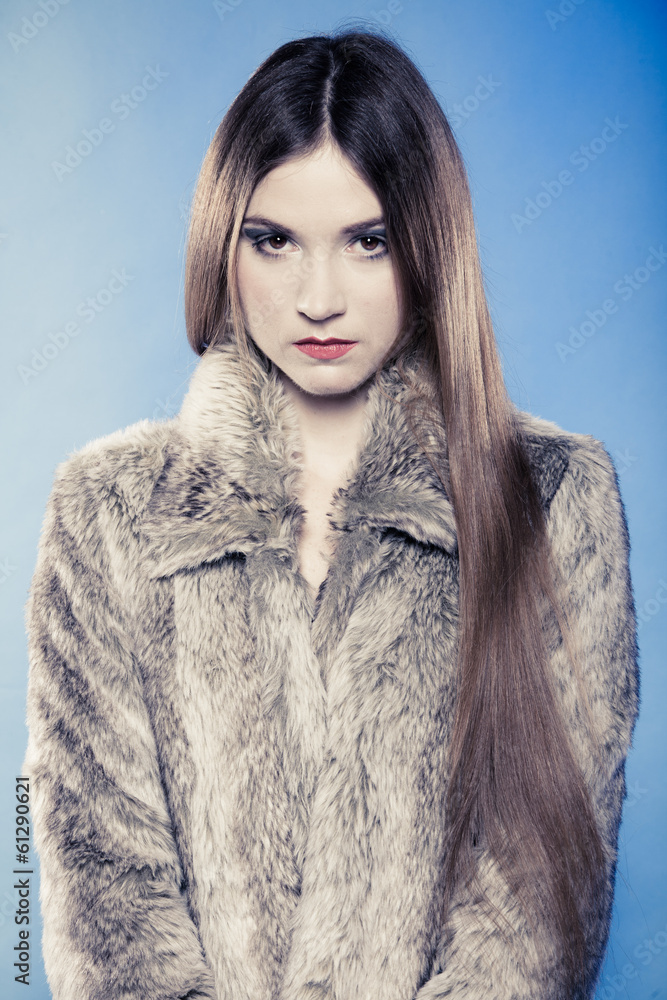 Girl with long hair. Young woman in fur coat on blue. Girl with long hair. Young woman in fur coat on blue.