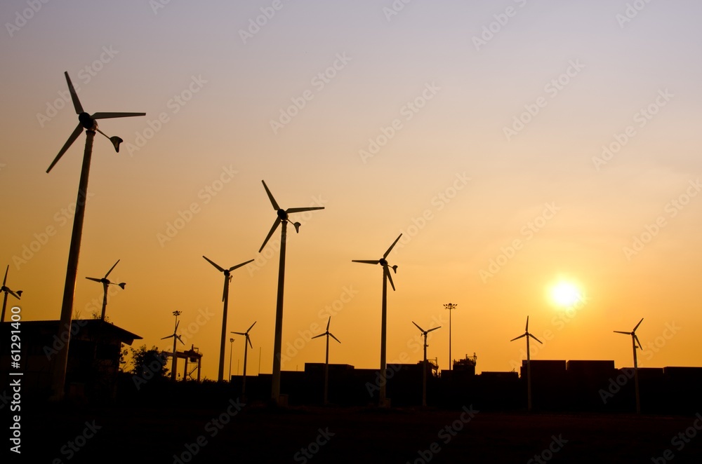 Clean energy wind turbine silhouettes at sunset