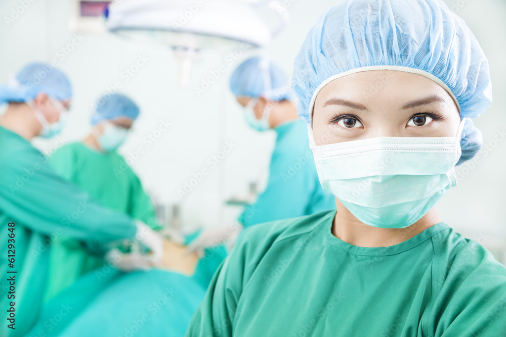 Asian Surgical woman and Surgeons in an operating theater Asian Surgical woman and Surgeons in an operating theater