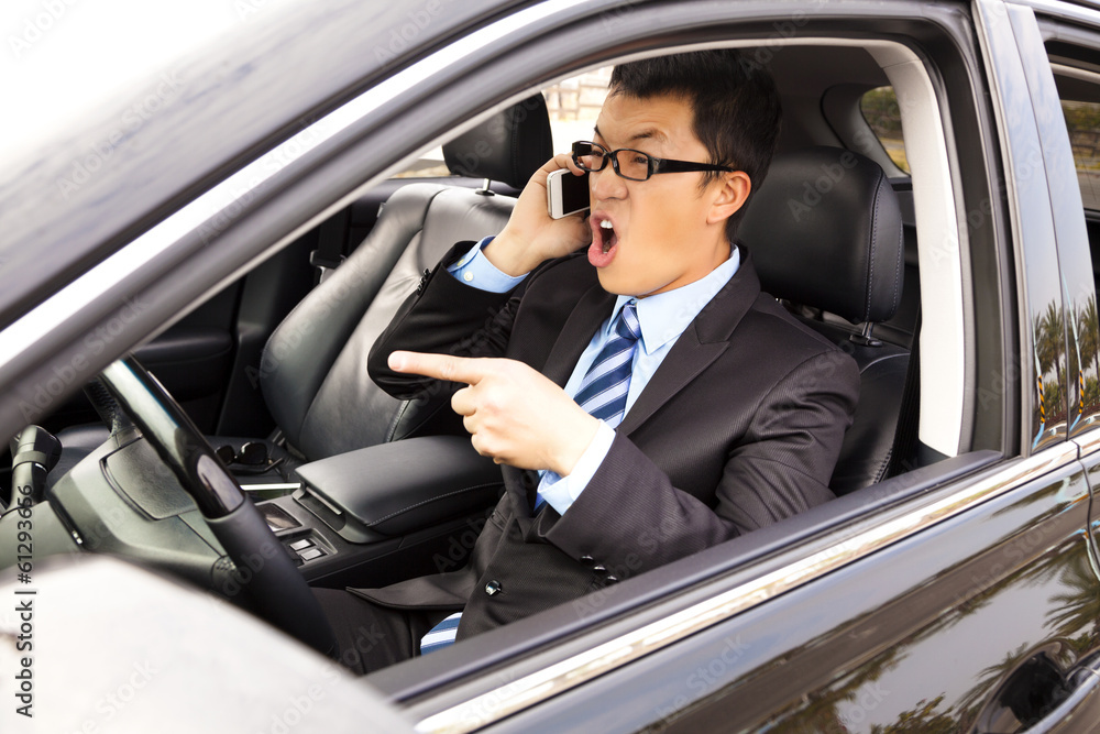 irate businessman talking with cell phone in the car irate businessman talking with cell phone in the car
