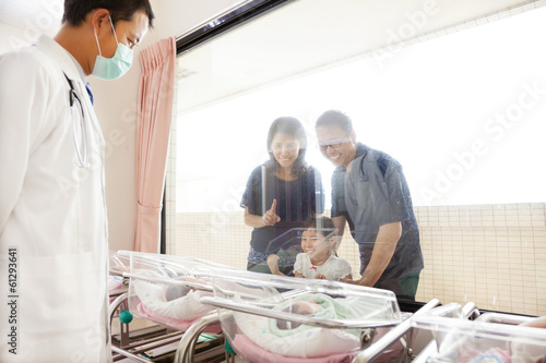 Family watching newborn in childbearing center and doctor