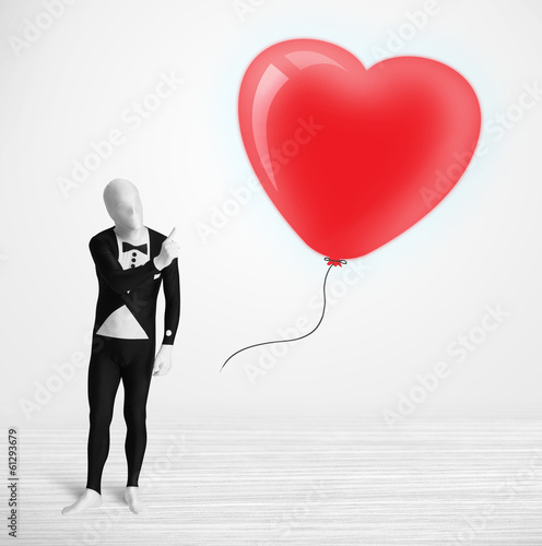 Cute guy in morpsuit body suit looking at a balloon shaped heart photo