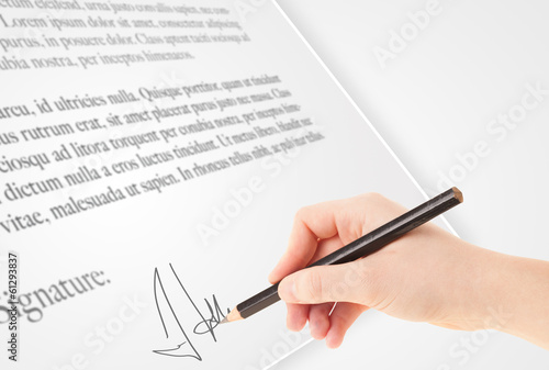 Hand writing personal signature on a paper form