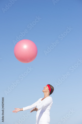Happy senior woman and flying exercise ball © roboriginal