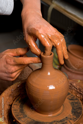 hands of a potter, creating an earthen jar