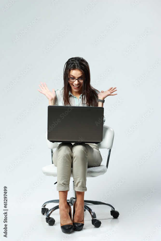 businesswoman with laptop sitting on chair on gray background