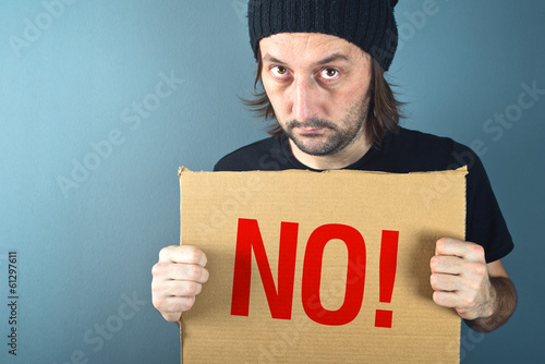 Man holding cardboard paper with word No