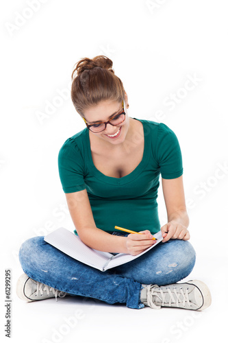 Female student sitting crossed legs, writing