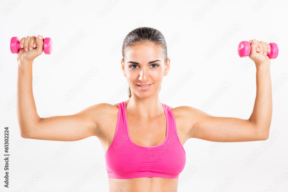 Young beautiful woman exercising with dumbbells. Young beautiful woman exercising with dumbbells.