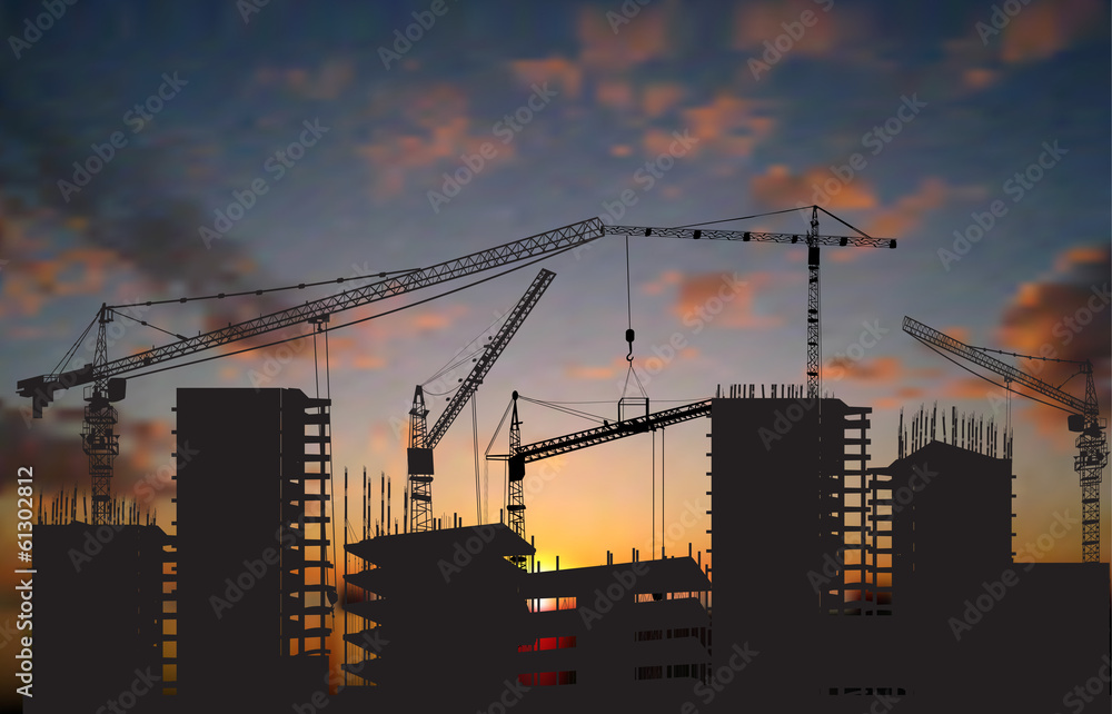 five cranes above buildings at dark sunset five cranes above buildings at dark sunset