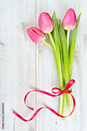 Fototapeta Naklejka Na Ścianę i Meble -  three pink tulips tied with a ribbon