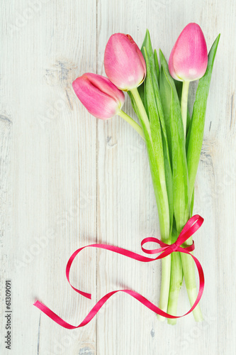 Fototapeta Naklejka Na Ścianę i Meble -  three pink tulips tied with a ribbon