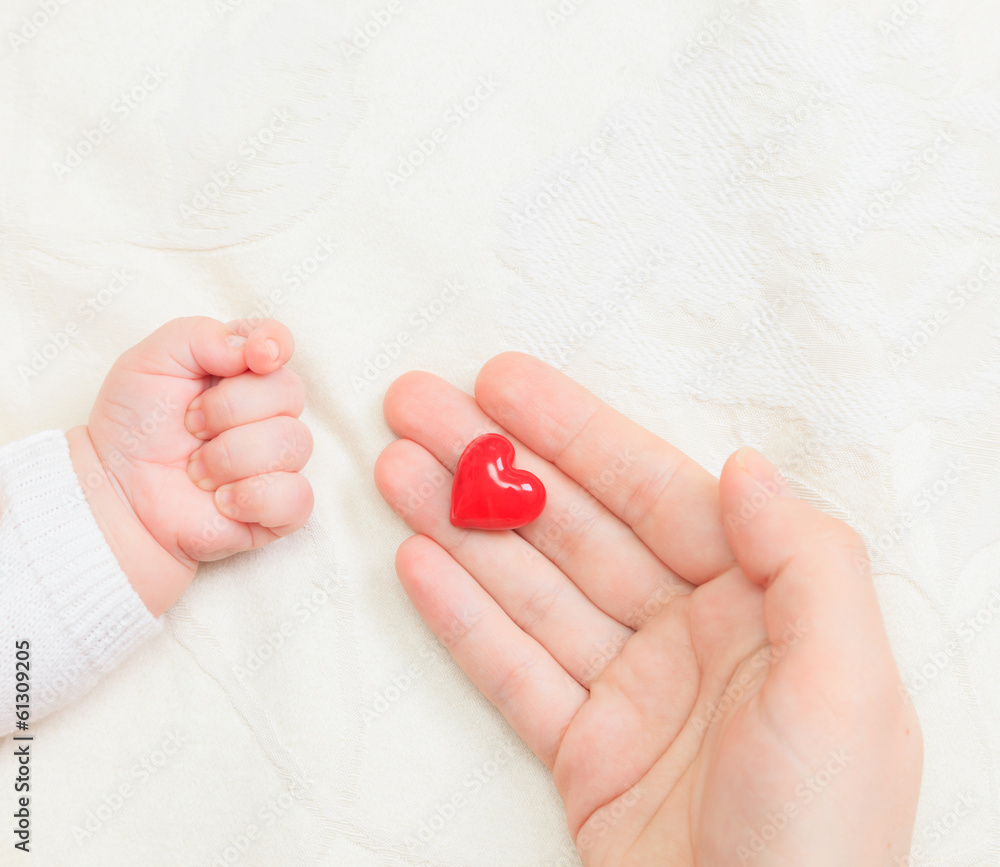 hands of mother and baby closeup holding heart hands of mother and baby closeup holding heart