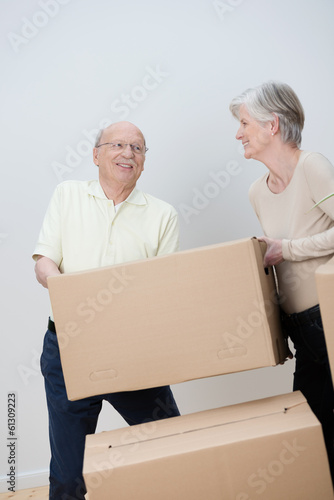 aktives älteres ehepaar trägt umzugskartons © contrastwerkstatt