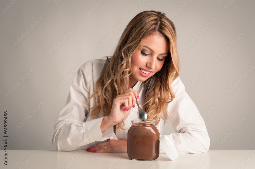 Blonde woman eating chocolate cream with teaspoon. Blonde woman eating chocolate cream with teaspoon.