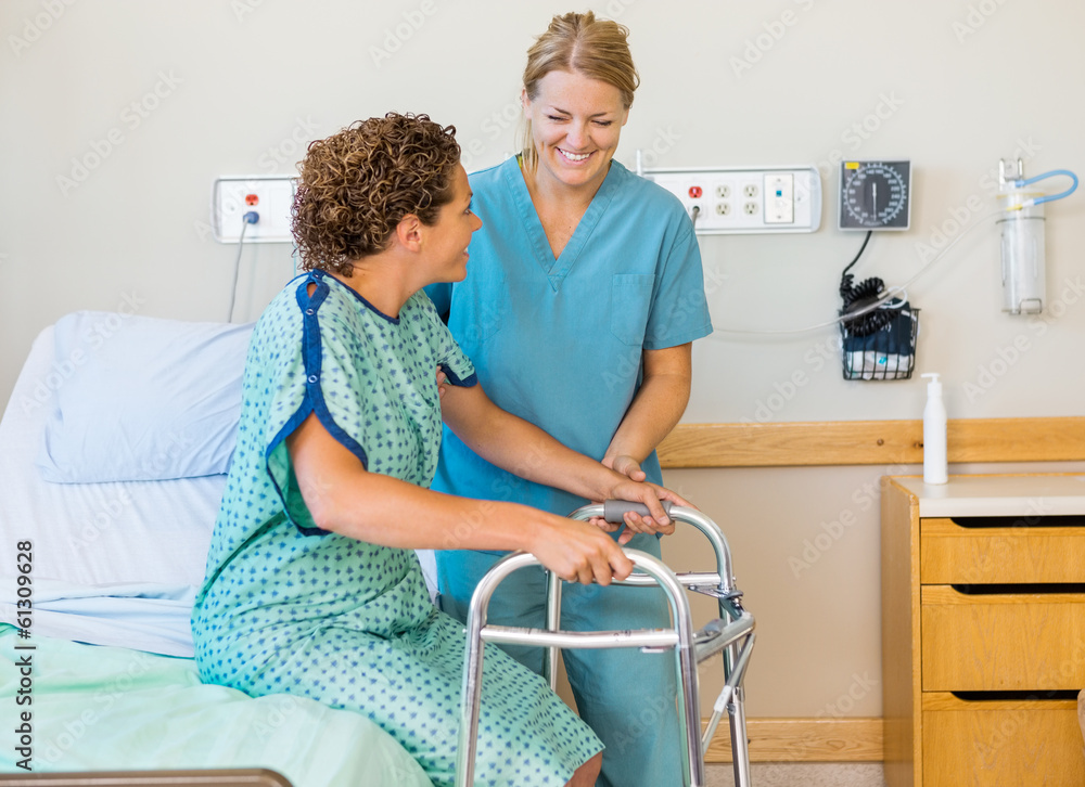 Fototapeta premium Nurse Assisting Patient Using Walking Frame In Hospital