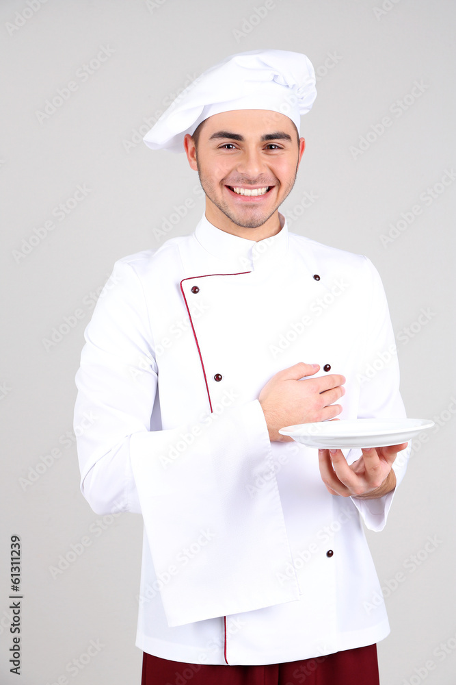 Professional chef in white uniform and hat, on gray background Professional chef in white uniform and hat, on gray background