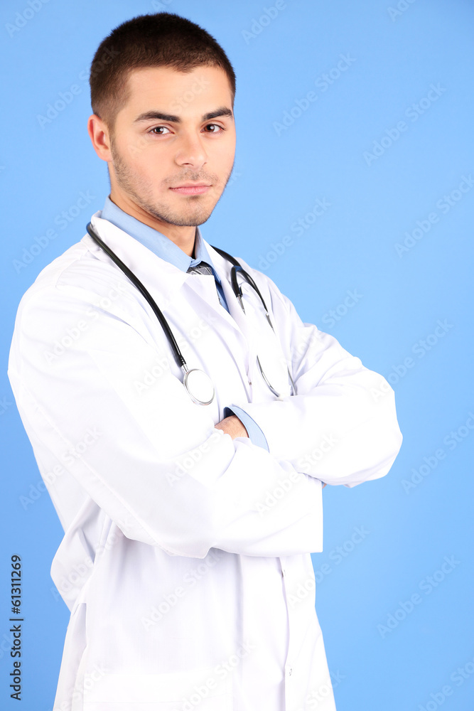 Male Doctor standing with folder, on blue background Male Doctor standing with folder, on blue background