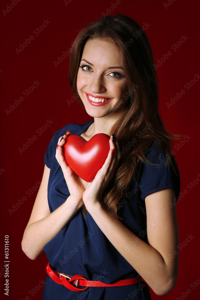 Attractive woman with heart, on red background Attractive woman with heart, on red background