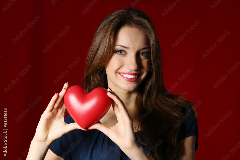 Attractive woman with heart, on red background Attractive woman with heart, on red background