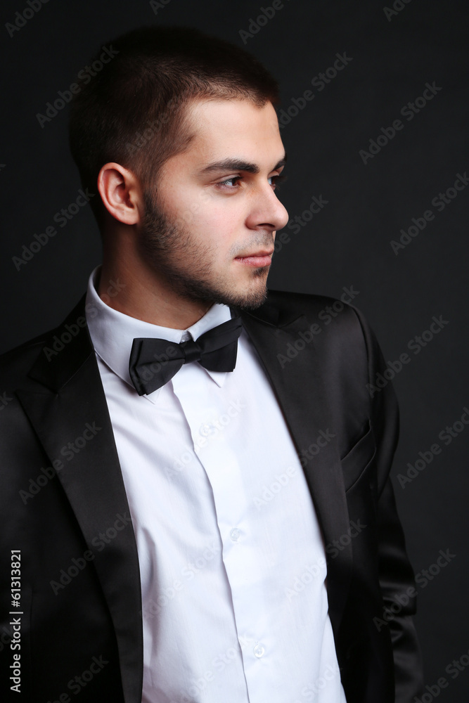 Handsome young man in suit on dark background Handsome young man in suit on dark background