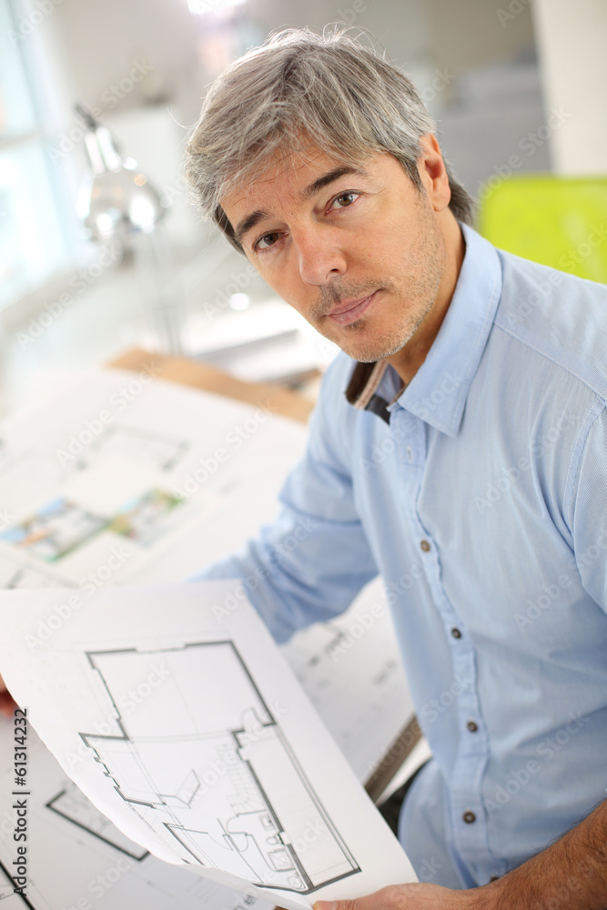 Architect working on blueprint in office Architect working on blueprint in office