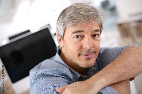 Smiiling mature man relaxing in office chair © goodluz