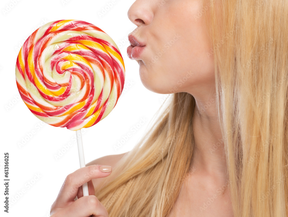 Closeup on young woman kissing lollipop