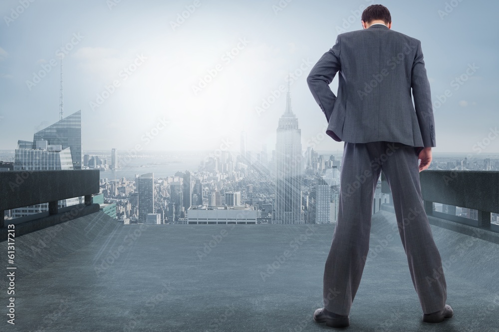 Composite image of businessman standing with hand on hip Composite image of businessman standing with hand on hip