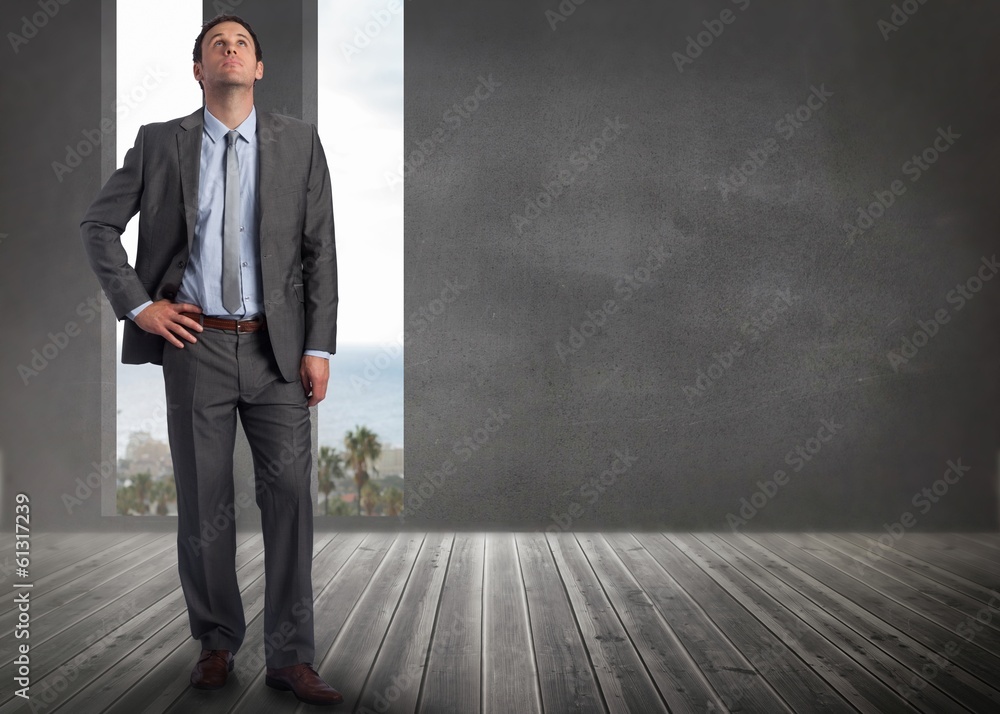 Composite image of serious businessman with hand on hip Composite image of serious businessman with hand on hip
