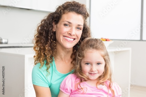 Happy mother and daughter looking at camera