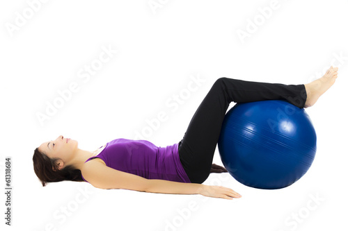 Young woman doing pilates ball exercises
