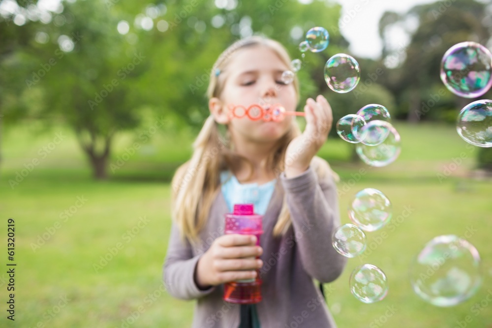 Girl blowing soap bubbles at park Girl blowing soap bubbles at park