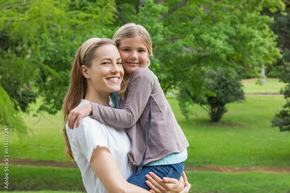 Fototapeta premium Mother carrying daughter at park