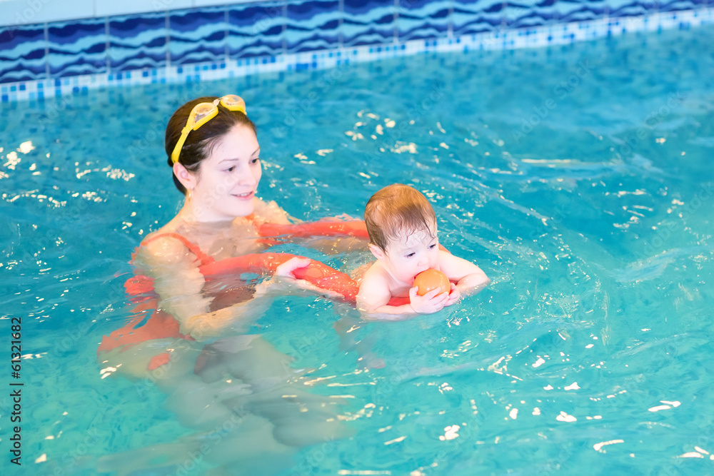 Baby playing with her mother in an early swimming class