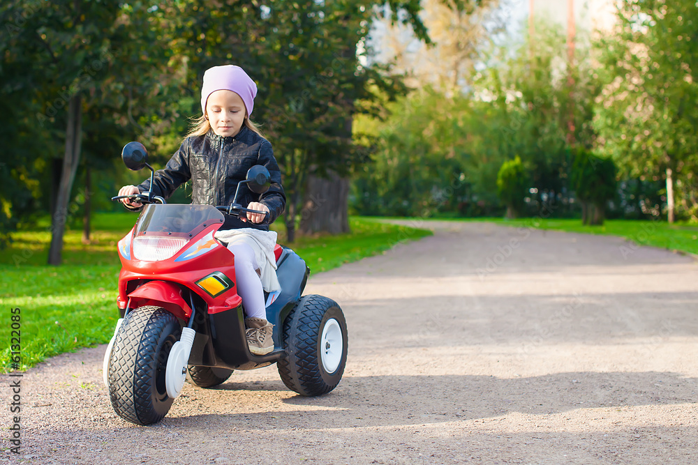 Little adorable girl having fun on her toy motorcycle Little adorable girl having fun on her toy motorcycle