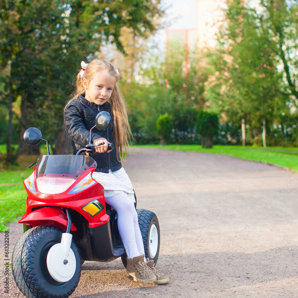 Little adorable rock girl in leather jacket sitting on her toy Little adorable rock girl in leather jacket sitting on her toy
