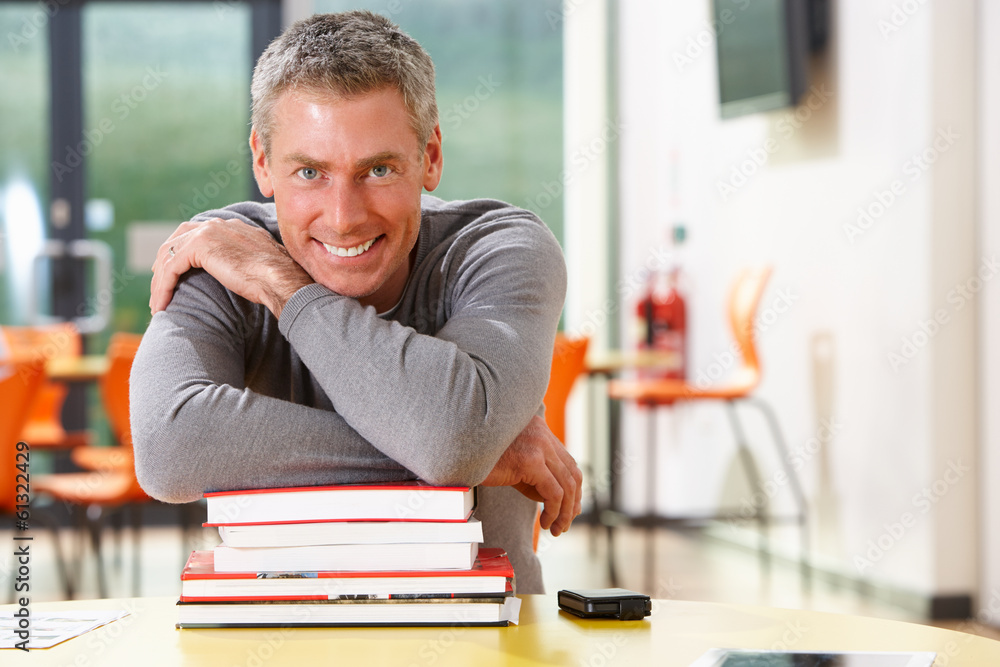 Male Mature Student Studying In Classroom With Books Male Mature Student Studying In Classroom With Books