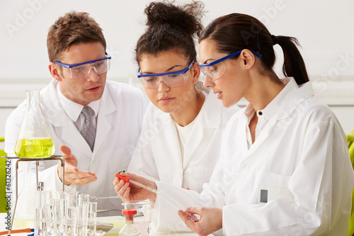 Group Of Scientists Performing Experiment In Laboratory