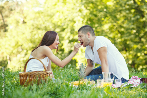 Young woman feeds her boyfriend with strawberries