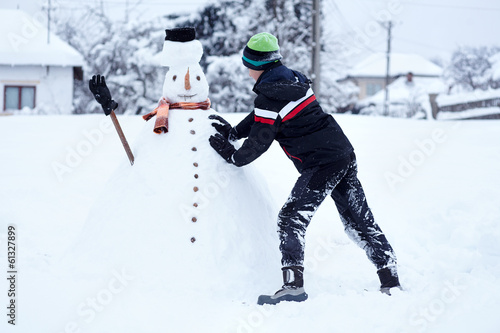 Teenager building a snowman