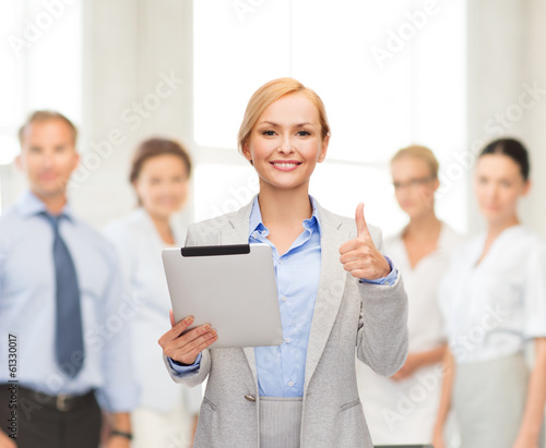 smiling woman with tablet pc showing thumbs up