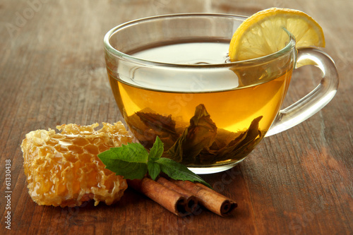 Transparent cup of green tea with honey and cinnamon