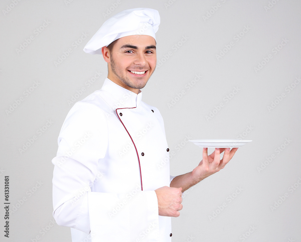 Professional chef in white uniform and hat, on gray background Professional chef in white uniform and hat, on gray background