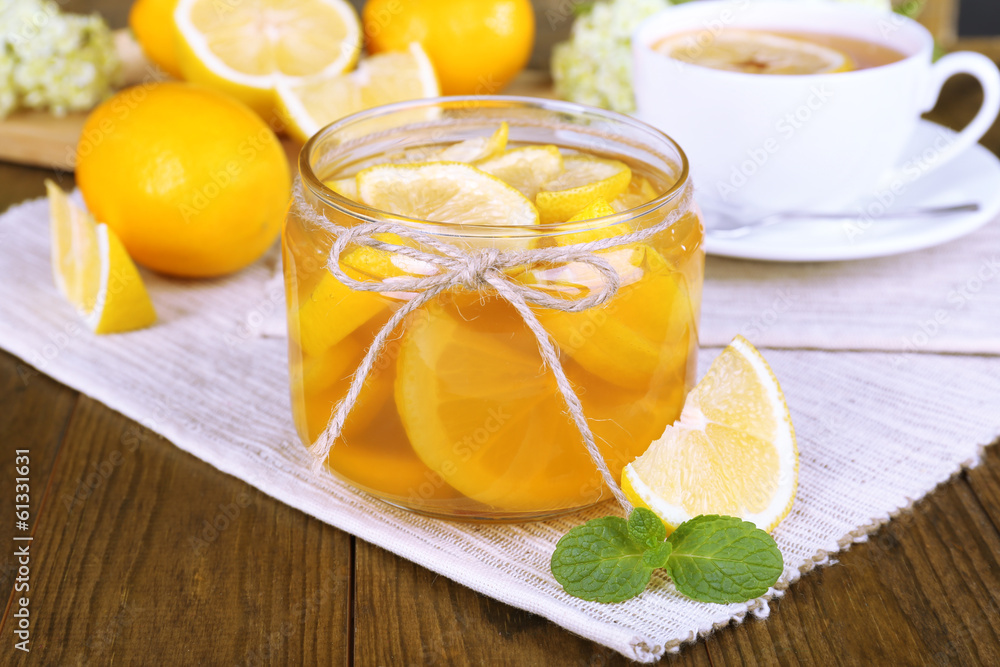Tasty lemon jam with cup of tea on table close-up Tasty lemon jam with cup of tea on table close-up