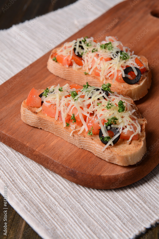 Delicious bruschetta with tomatoes on cutting board close-up Delicious bruschetta with tomatoes on cutting board close-up