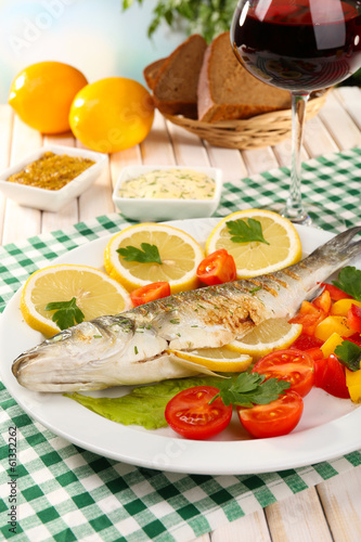 Delicious grilled fish on plate on table close-up