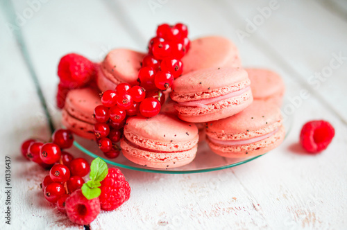 Raspberry macaroons with berries on wooden table