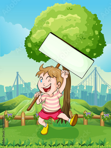 A happy boy near the tree with an empty board